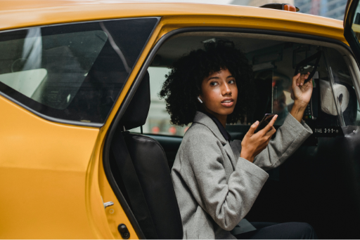 Woman smiling and getting into a taxi booked by Venue Butler